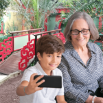 Mamie et son petit-fils qui se prennent en photo devant un décor asiatique
